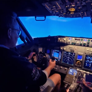 Kunde flyr Boeing 737 simulator hos Flight Simulations Norway med instruktør ved siden av